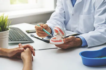 Dr showing tooth mold to patient