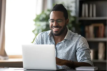 smiling man using laptop